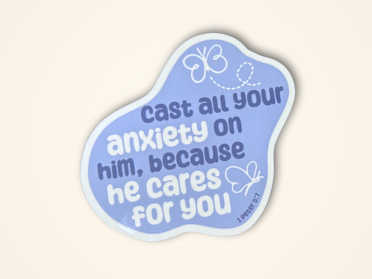 A sticker with a light blue design featuring the text 'cast all your anxiety on him, because he cares for you' from 1 Peter 5:7, decorated with white butterflies, on a cream background.