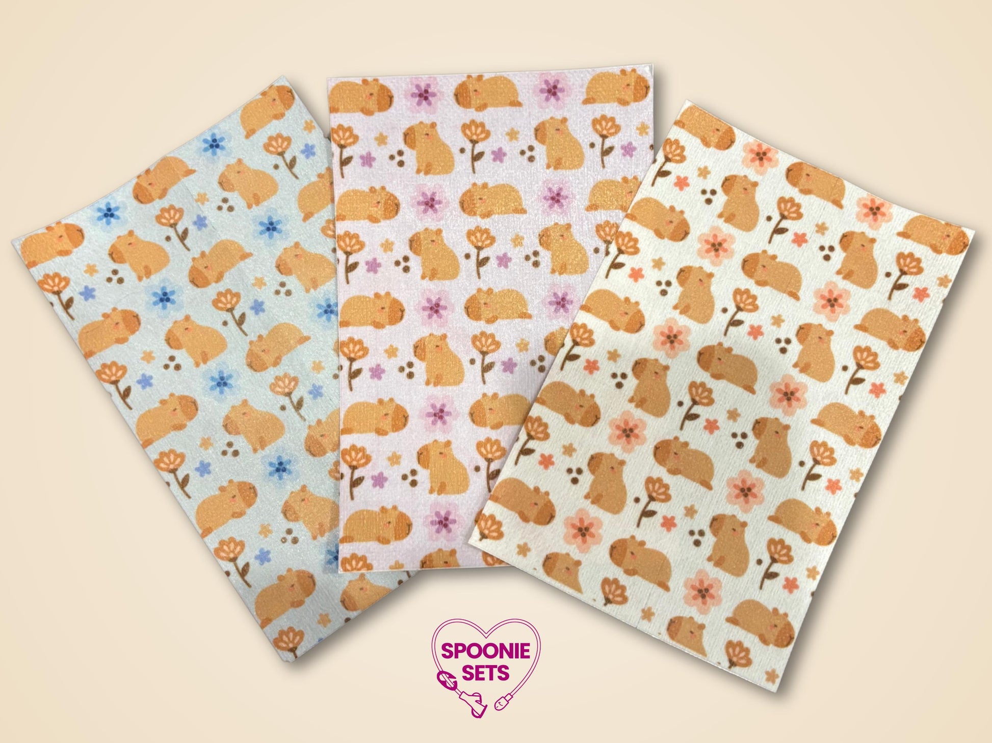 Three sheets of decorative Hypafix tubie tape featuring a capybara and floral pattern in blue, pink, and cream.