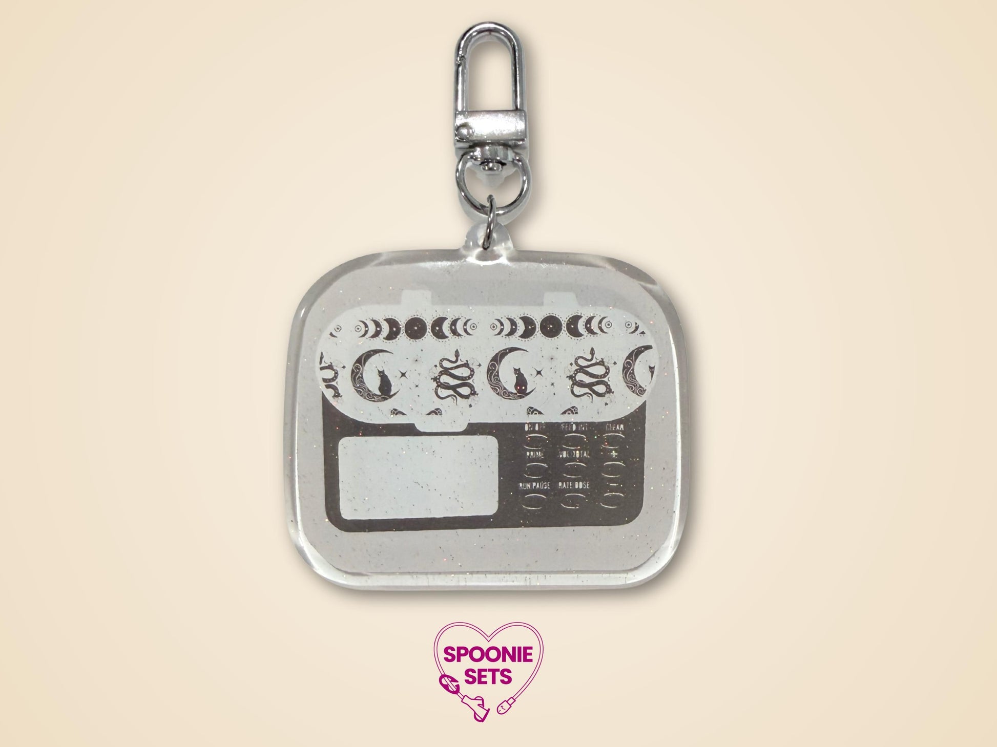 Keychain with white, light gray, and dark gray feeding tube pump design with celestial accents and silver hardware