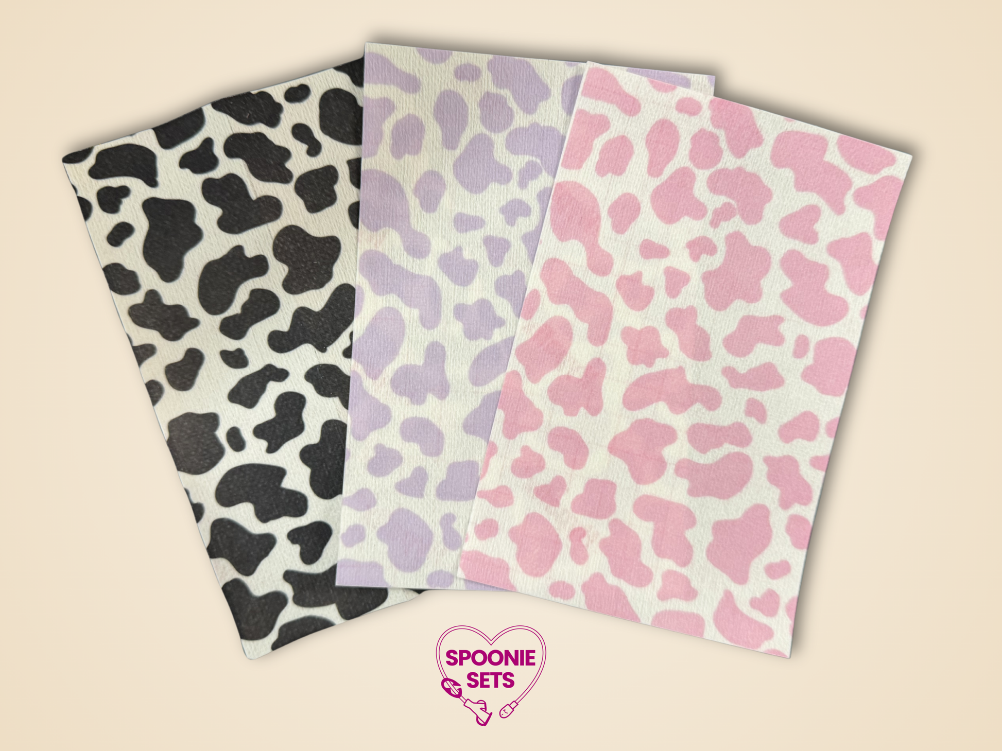 Three sheets of Hypafix tubie tape with black, pink, and purple cow print designs.
