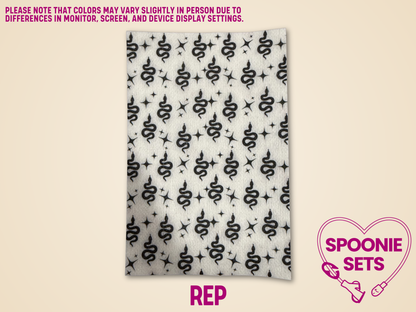 Decorative Hypafix tubie tape with black snakes and stars on a light background.