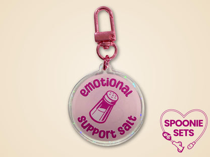 Pink holographic acrylic keychain with "Emotional Support Salt" text and a salt shaker design.
