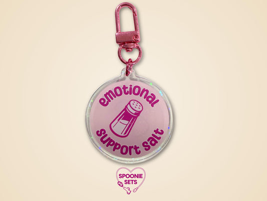 Pink holographic acrylic keychain with "Emotional Support Salt" text and a salt shaker design.
