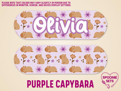 Two matte, laminated feeding tube pump stickers with a purple capybara and floral design. One features the name "Olivia.