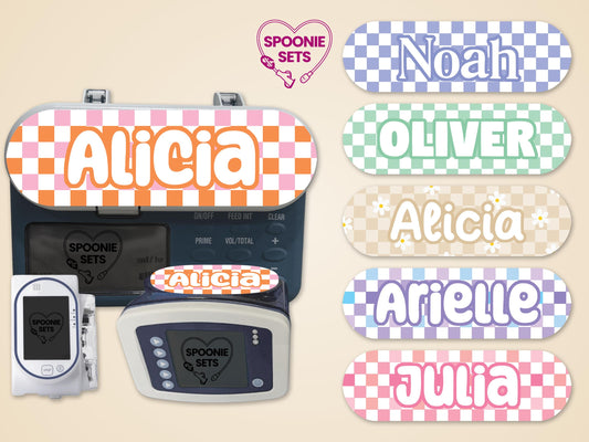 Pink and orange checkered "Alicia" feeding tube pump sticker on a pump, with other colorful name stickers.