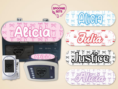 Pink ribbon "Alicia" feeding tube pump sticker on an Infinity pump, with other personalized ribbon and cherry designs.