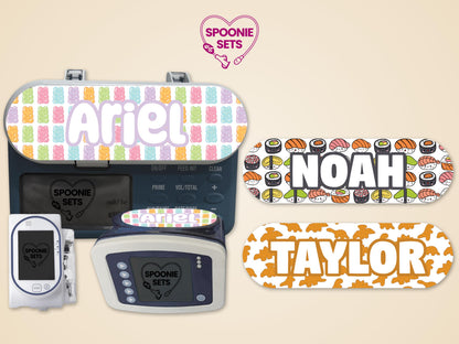 Feeding tube pump stickers: gummy bears for "Ariel," sushi for "Noah," and dino nuggets for "Taylor.
