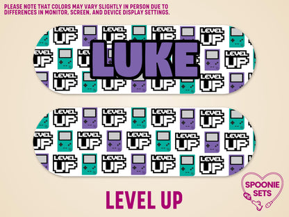 Matte feeding tube pump sticker with "LUKE" in purple, surrounded by 16-bit video game controllers and "LEVEL UP" text.
