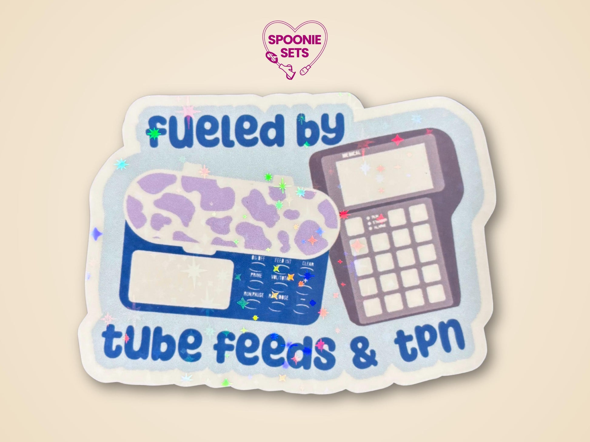 Holographic sticker with "Fueled by Tube Feeds & TPN" text, featuring a blue feeding tube pump with purple cow print and a TPN pump.