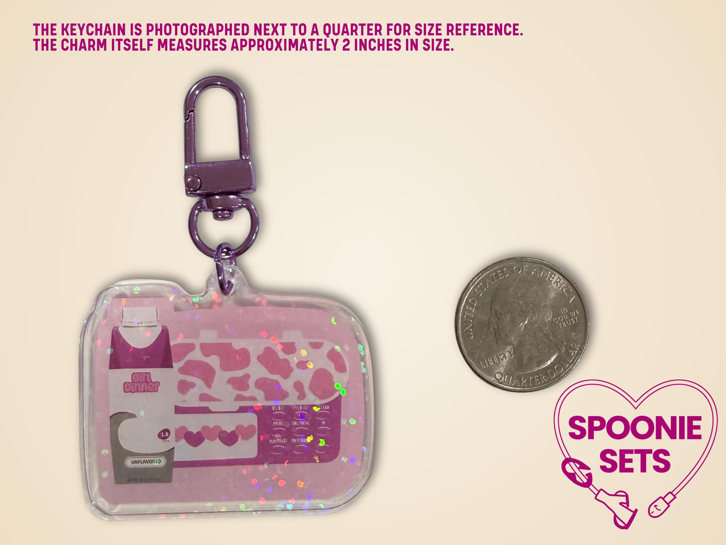 Pink "Girl Dinner" acrylic keychain with feeding tube pump and formula bottle design, holographic dot overlay, next to a quarter.