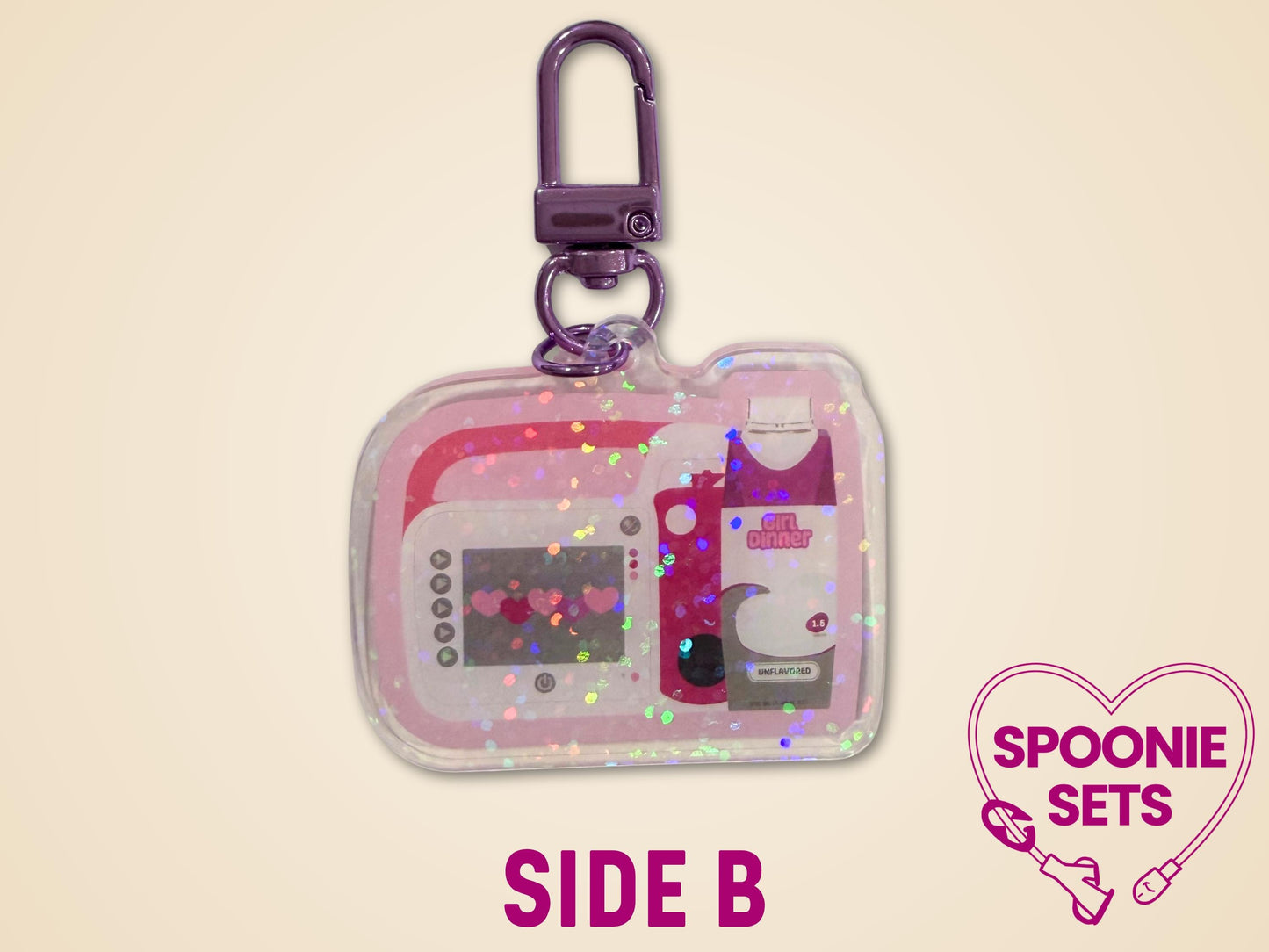 Pink acrylic keychain with holographic dots, featuring a feeding tube pump and "Girl Dinner" formula bottle design.