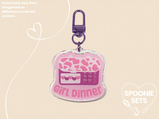 Pink acrylic keychain with a feeding tube pump design, "Girl Dinner" text, and holographic dot overlay.