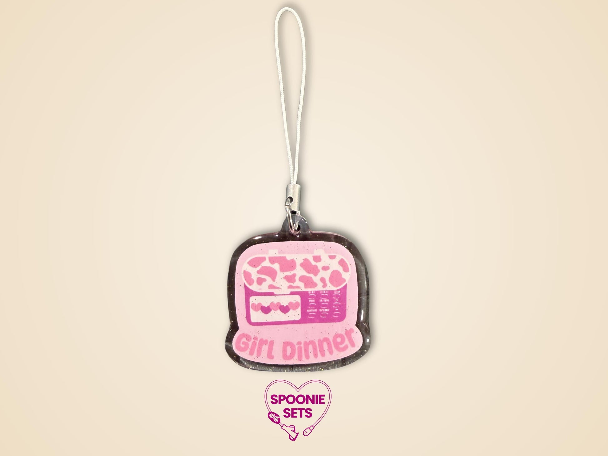 Pink glitter epoxy acrylic phone charm with "Girl Dinner" and a feeding tube pump design.