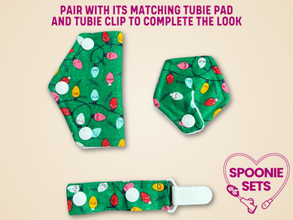 Green patterned tubie pad, clip, and spoonie set on a beige background with promotional text.