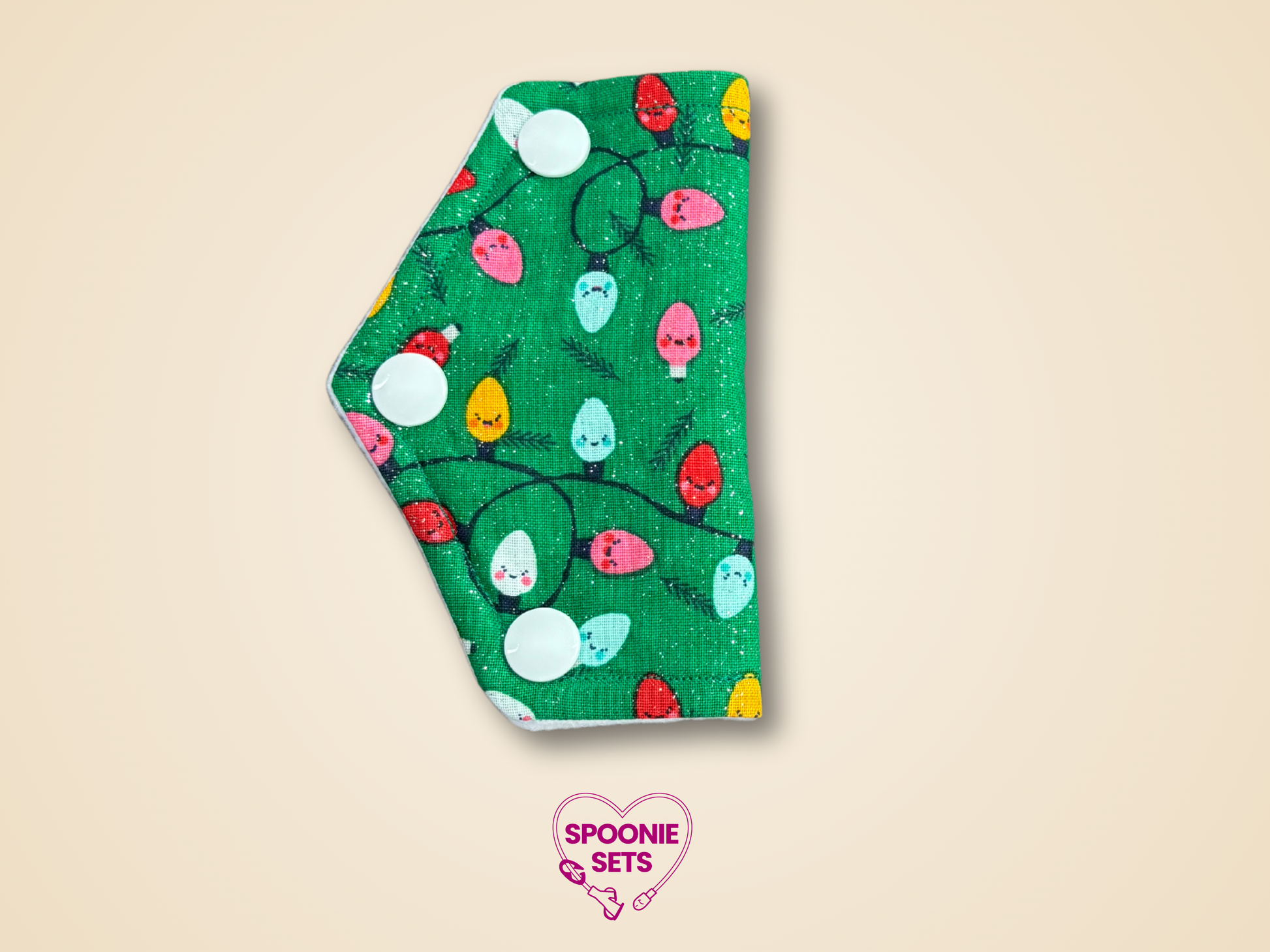 Green port cover with colorful Christmas lights pattern on a beige background, featuring 'Spoonie Sets' logo.