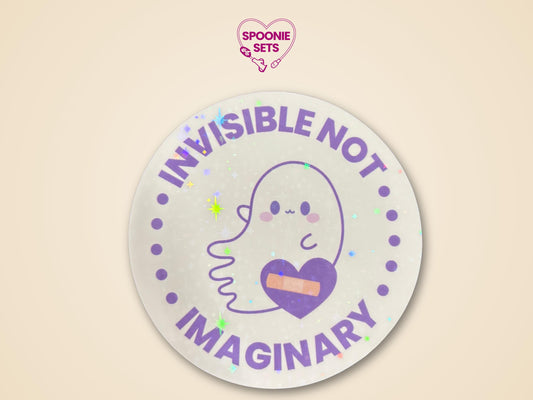 Round holographic glitter sticker with a cute ghost, purple heart with a bandage, and "Invisible Not Imaginary" text.
