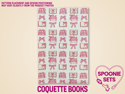 White Hypafix tubie tape with rows of pink bows, open books, and stacked books.