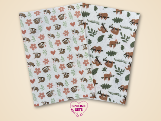 Two sheets of Hypafix tubie tape with floral sloth designs, one with pink flowers and one with green leaves.