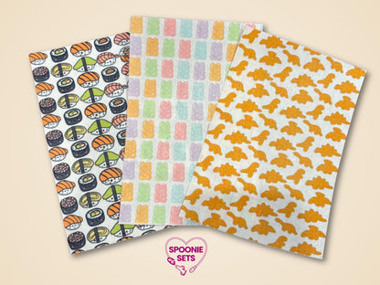 Three decorative Hypafix tubie tape sheets: sushi, colorful gummy bears, and orange dino nuggets.