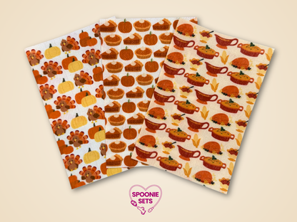 Three sheets of Hypafix tubie tape with Thanksgiving designs: pumpkin pie, holiday dinner, and turkeys with pumpkins.