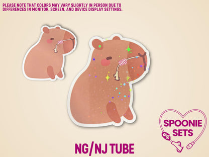 Two matte capybara stickers with feeding tubes, one with glossy laminate, one with holographic glitter.