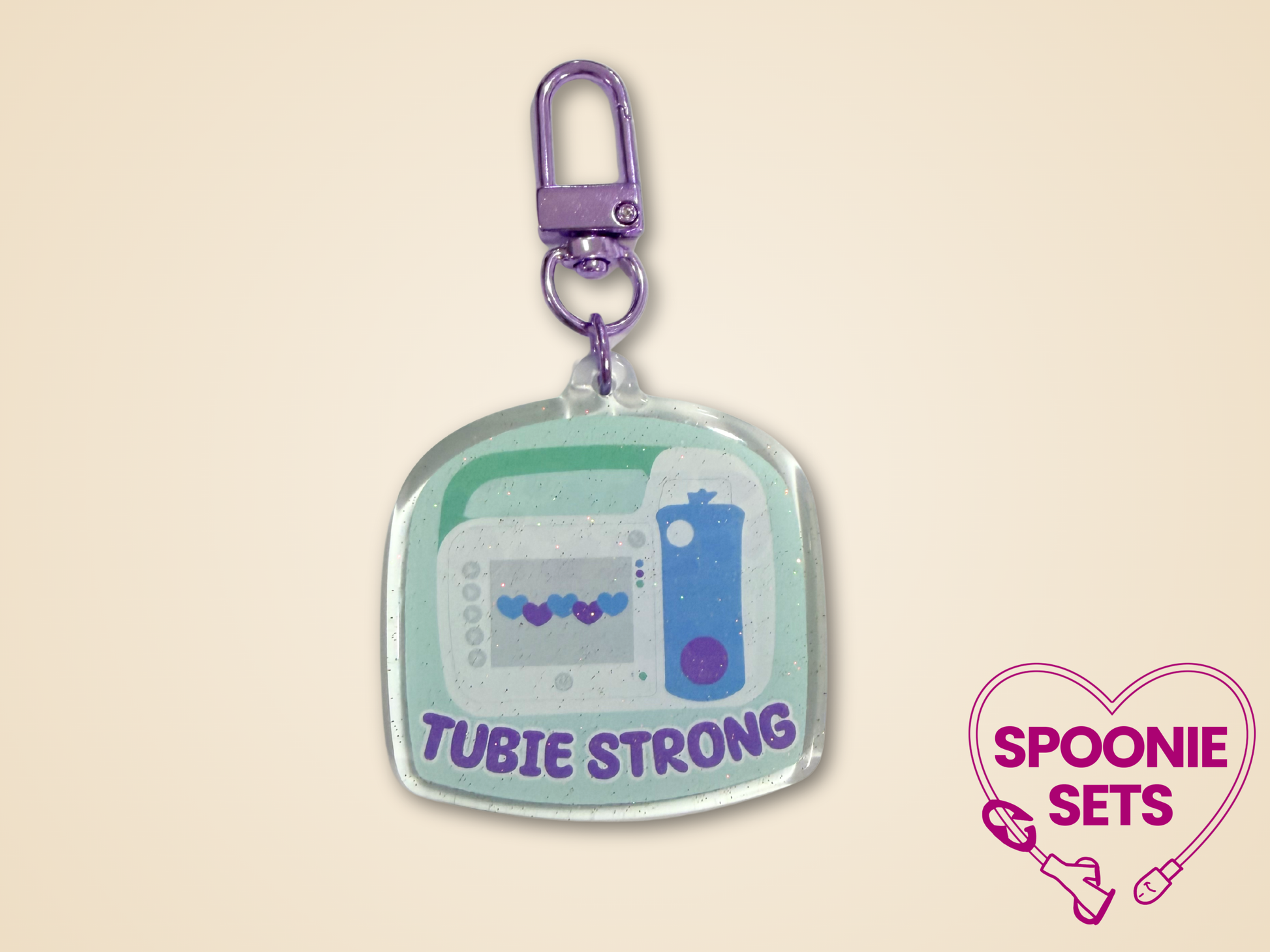 Keychain with purple, blue, and green design  of feeding tube pump and 'Tubie Strong' text.