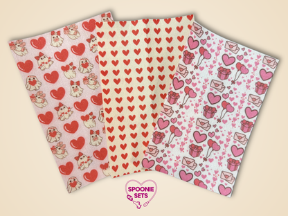 Three sheets of Valentine's Day tubie tape with red hearts, pink balloons, gift boxes, and cute animal designs.